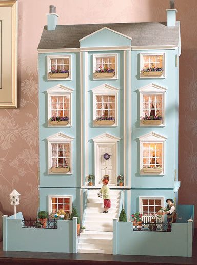 lovely blue and white dolls house in a georgian townhouse style on a coffee table with a basement in a living room.