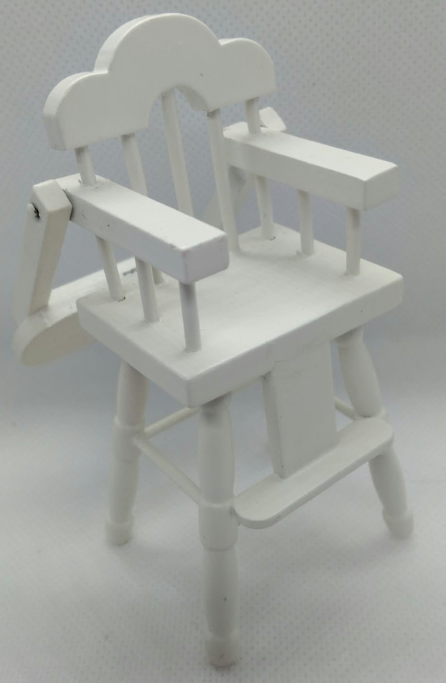 white highchair in miniature on a white background 