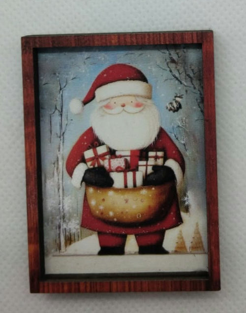 lovely dolls house santa picture carrying his sack of presents hanging on a white background wall.