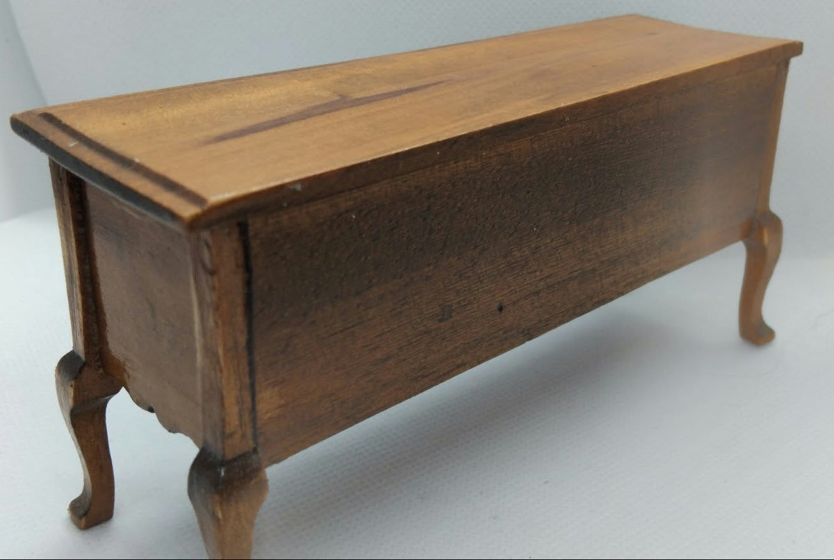 A small wooden sideboard with curved legs, shown on a plain light gray studio background.