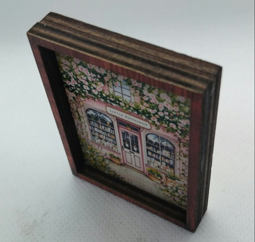 miniature cottage picture for a dolls house in a thick brown frame on a light background