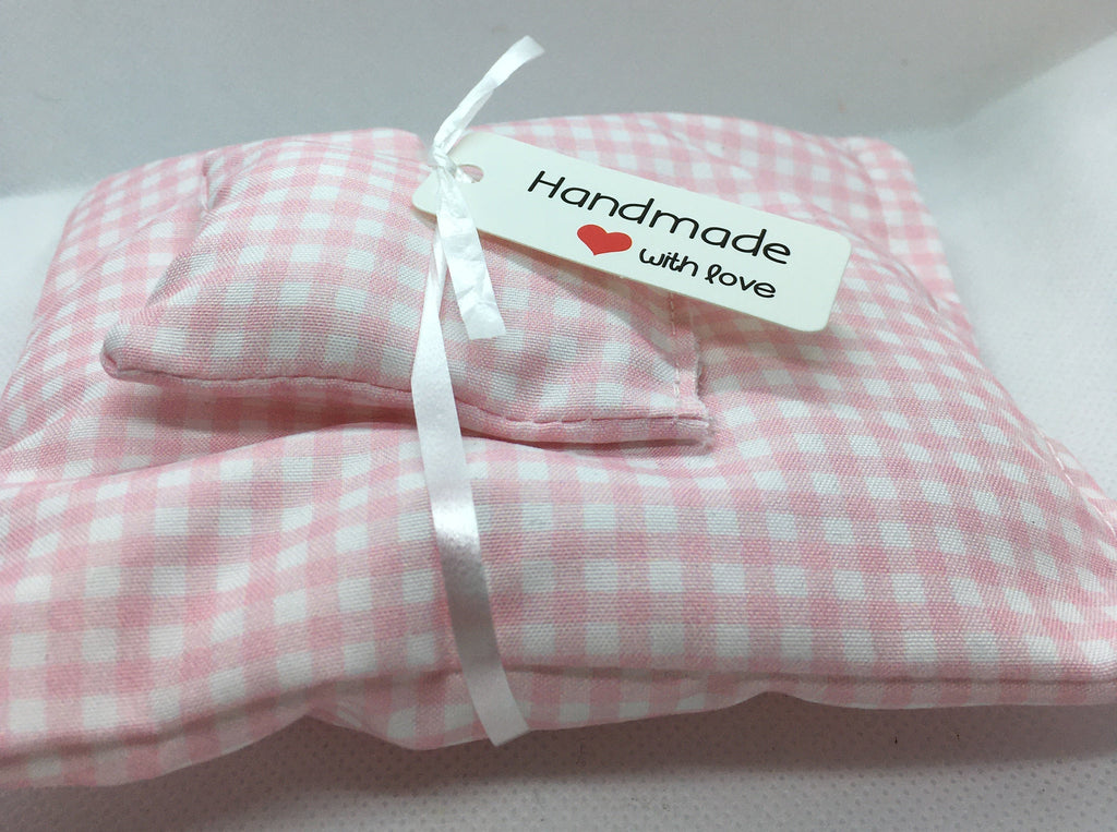 A folded pink and white gingham fabric miniature duvet set tied with a white ribbon and a small white tag that reads 'Handmade with love'. 
