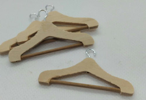four wooden miniature coat hangers on a white background