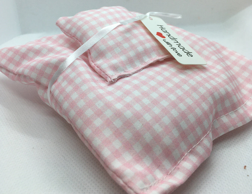 A small pink and white gingham check fabric miniature duvet set with a white ribbon and a small paper tag that reads 'handmade with love' photographed on a white fabric surface.