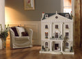 Model of a large dollhouse in a room with a chair and decor