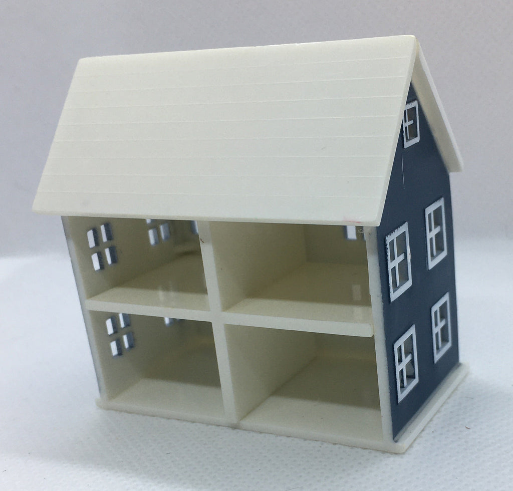 A miniature dollhouse-style house model with an off-white interior and exterior, featuring a dark blue side wall with white window details, set against a plain light gray background.