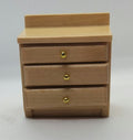 A miniature three-drawer wooden bedside  cabinet with small gold knobs, photographed against a plain white background .
