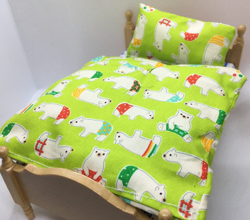 A miniature wooden bed frame shown with a bright lime green bedding set featuring a white polar bear pattern with red, green, and orange accents, photographed against a plain white background.