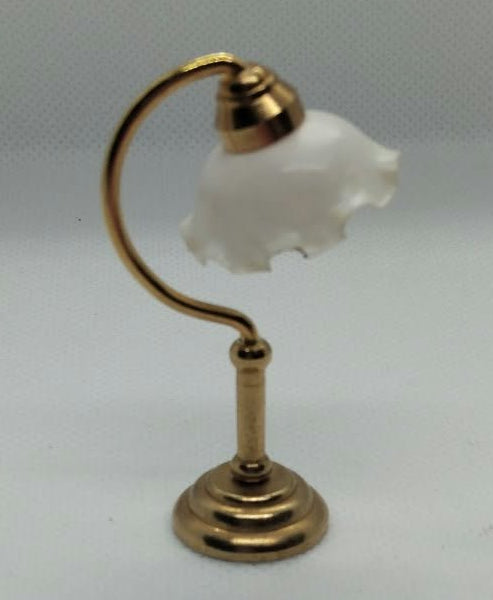 A miniature gold-colored metal desk lamp with a small white flower-shaped glass shade, set against a plain white background.