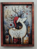 A framed Christmas-themed art print featuring a white deer with red antlers and a red Santa hat, in miniature on a white background.